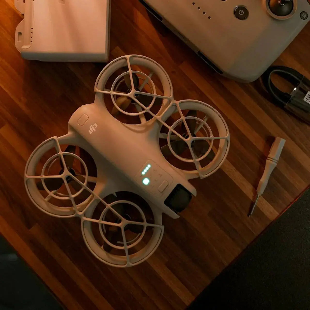 DJI underwater drone with protective propeller guards on wooden surface with remote and accessories