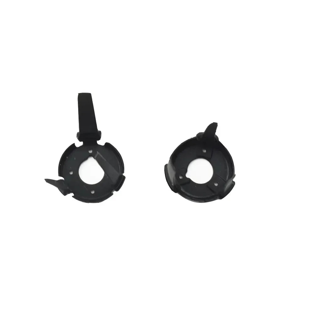 Two black plastic headlight bulb holders with clip attachments on a white background
