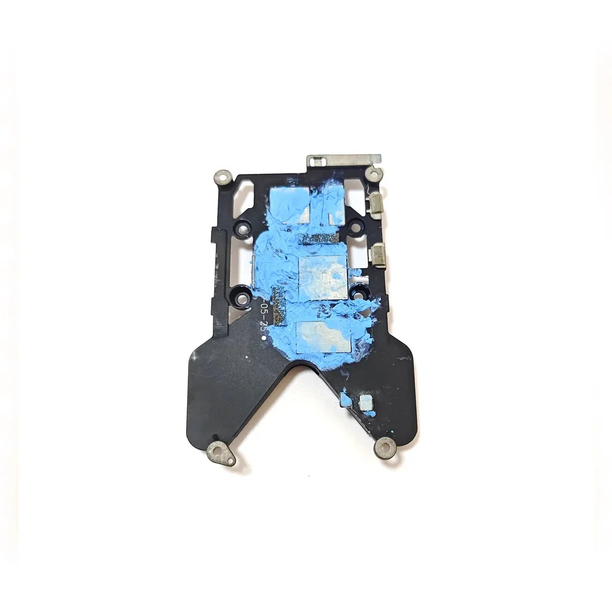 Black metal electronic component plate with worn blue thermal paste on white background