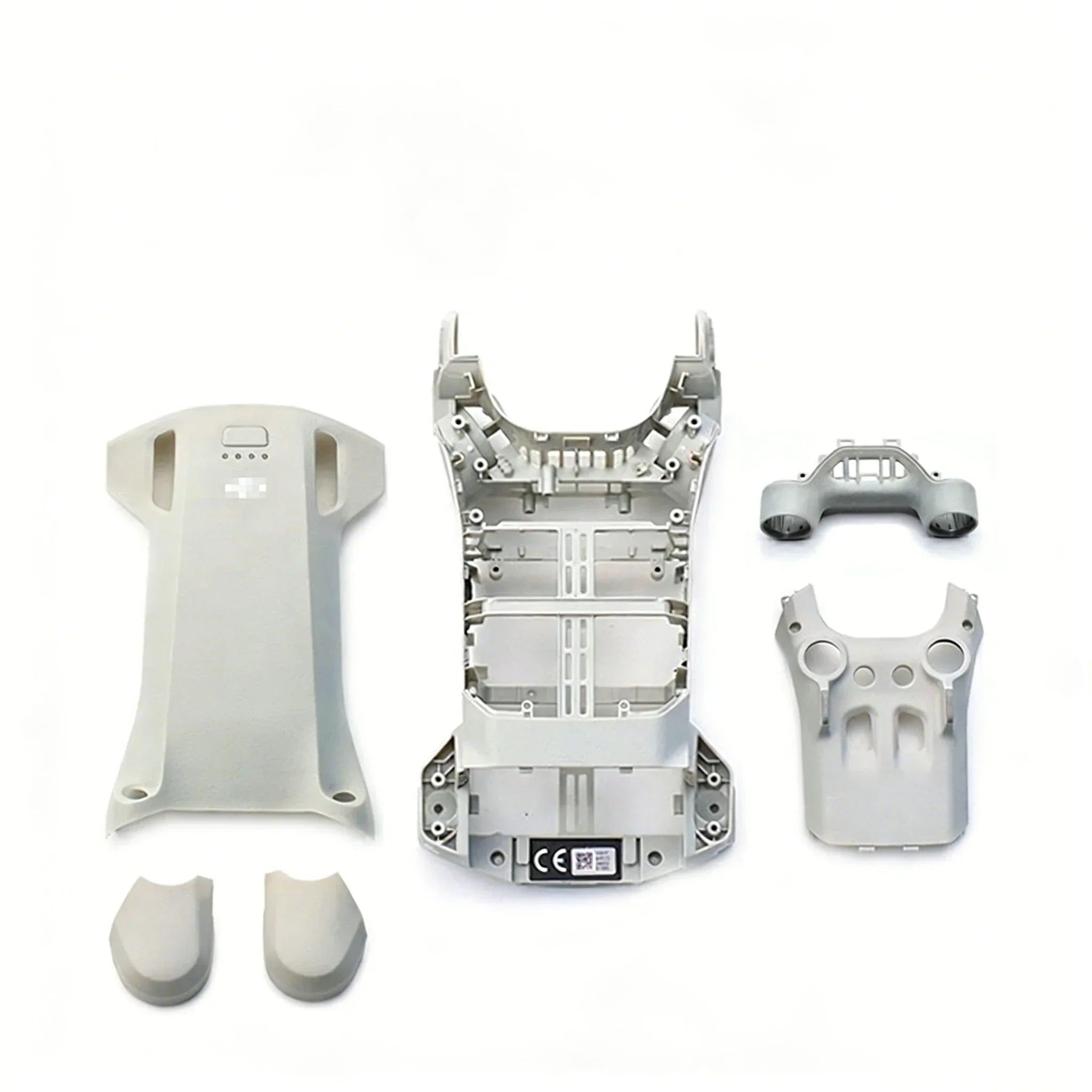 Grey drone shell parts and controller housing disassembled on white background