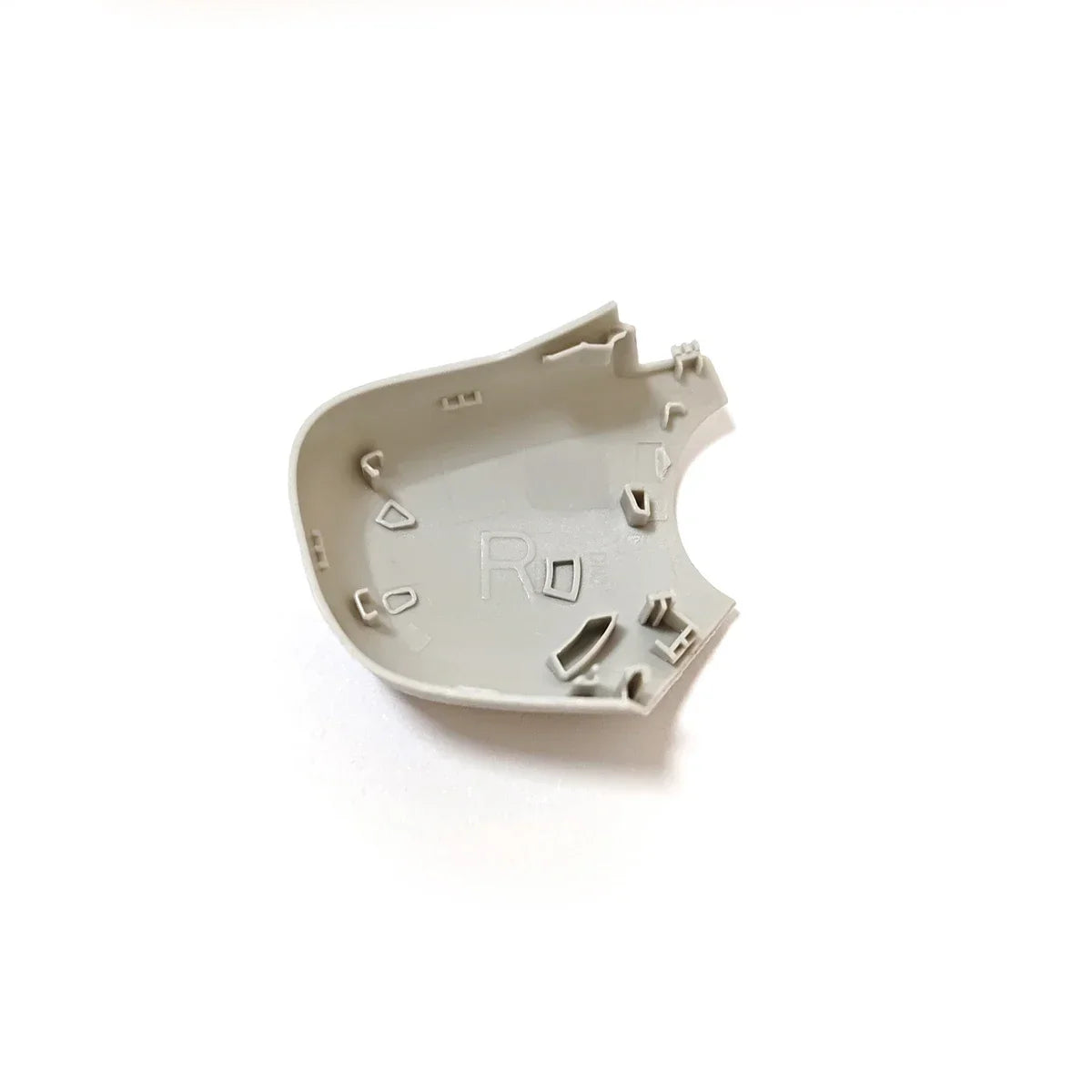 Beige plastic interior cover part with letter R embossed, likely a car mirror housing component